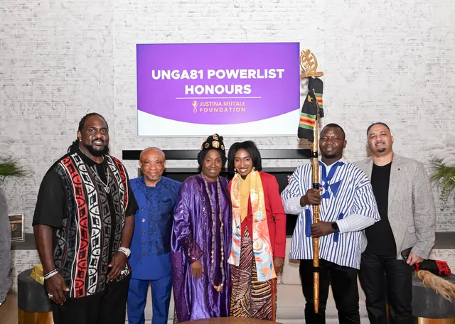 H.E. Rev. Dr. Ocansey with guests and the gold staff beneath the UNGA81 Powerlist Honours screen