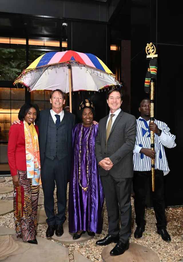 Guests gather with H.E. Rev. Dr. Ocansey beneath the ceremonial umbrella